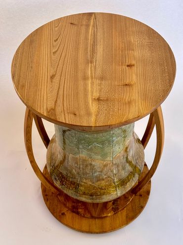 Wooden stool with a round seat and unique design.
