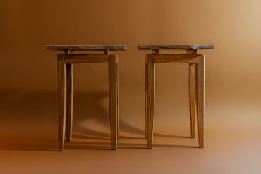 Two wooden stools against a brown background.