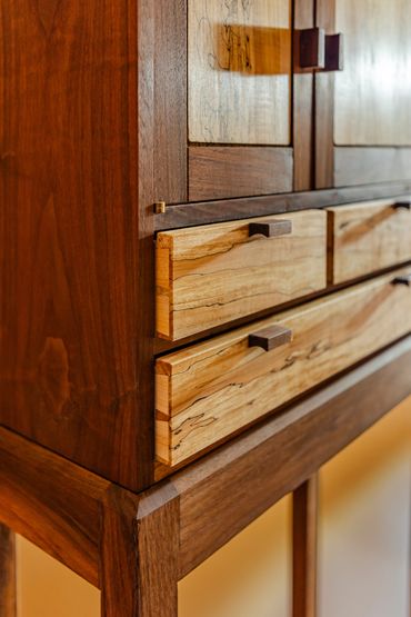 Close-up of wooden cabinet drawers with natural wood grain.