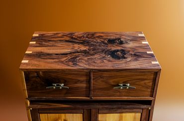 Wooden cabinet top with natural grain and brass handles.