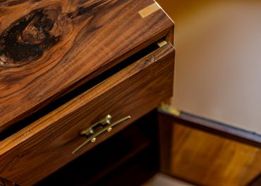 Close-up of a wooden drawer with brass handle.