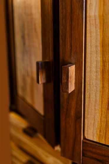 Close-up of wooden cabinet doors with square handles.
