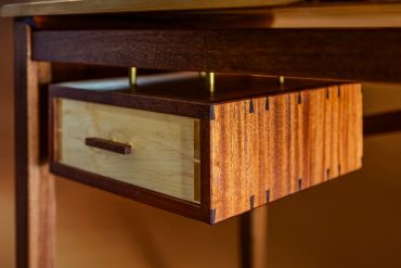 Close-up of a wooden drawer under a table.