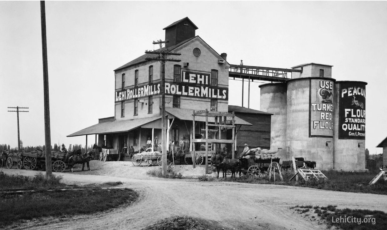 Historic Lehi Roller Mills with horse-drawn wagons and workers.