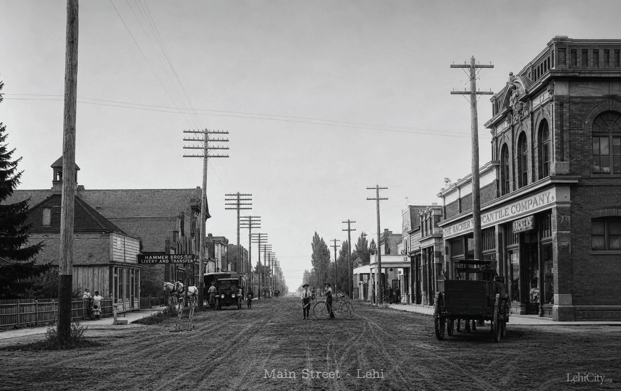 Historic main street scene in Lehi with horse-drawn carriage and early automobiles.