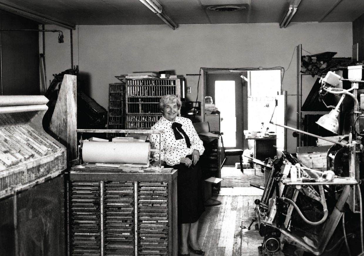 Woman smiling in an old printing workshop.