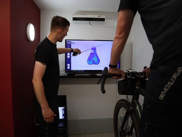 A professional coach teaching a cyclist the correct position