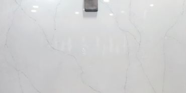 White marble surface with faint grey veins and a metal fixture.