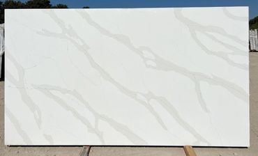 Large white marble slab with gray veining outdoors.