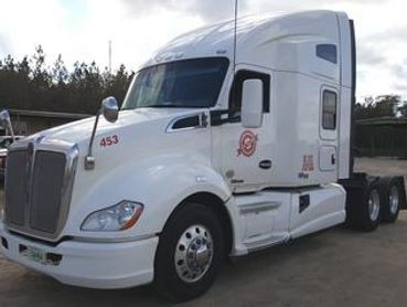 White Kenworth semi-truck cabin view.