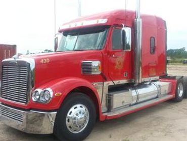 Red Peterbilt semi-truck side view.