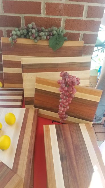 Stacked wooden cutting boards with a bunch of grapes on top.
