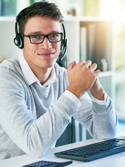 Young man with headset working at a computer.