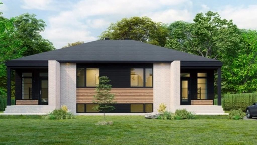 Maison moderne avec toit noir et mur en briques claires.