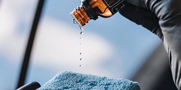 Droplets falling from a bottle onto a blue cloth.
