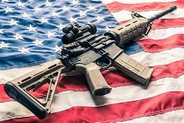 A tactical rifle resting on an American flag.