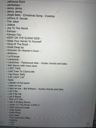A list of song titles and guitar chords on a screen.