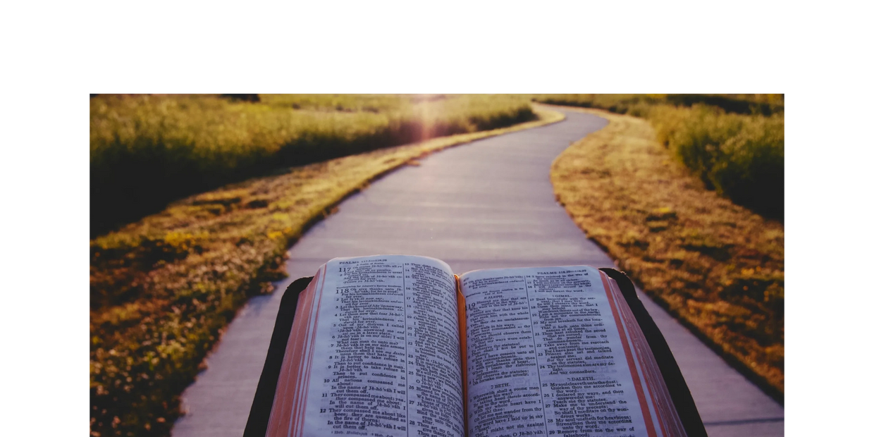 una biblia abierta con un camino de cemento