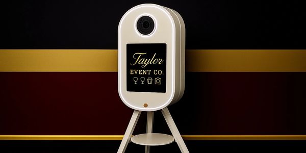 A sleek photo booth with "Taylor Event Co." branding on a gold and black background.
