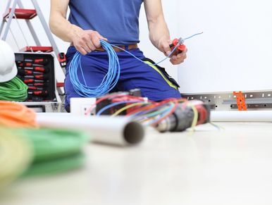 electrician at work with nippers in hand cut the electric cable