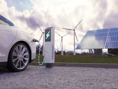 Using of charge station, solar panel and windmill background.
