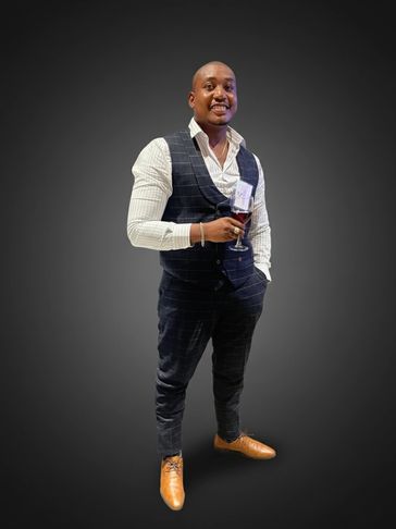 Well-dressed man holding a glass of red wine, smiling confidently.