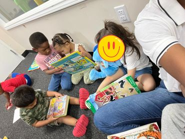 Children sitting on the floor, engaged with books and toys in a cozy reading area.