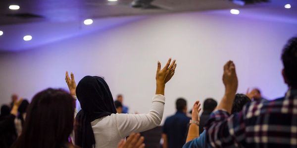 personas adorando con sus manos levantadas en iglesia cristiana evangelica