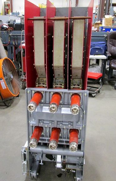 Industrial electrical equipment with red insulators and metal components.