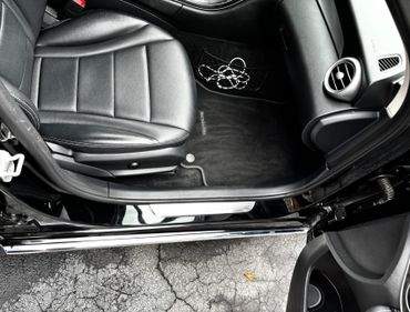 Interior view of a Mercedes-Benz car's passenger side with black leather seats.
