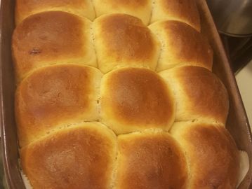 15 dinner rolls baked in a pan and brushed with butter