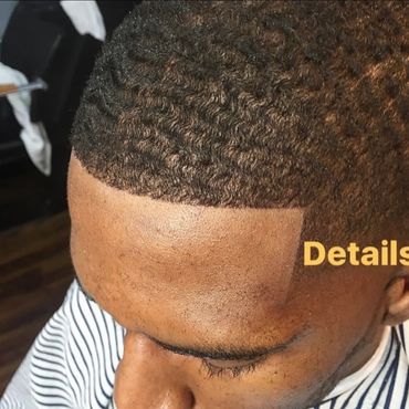 Close-up of a fresh, detailed haircut with waves and a sharp hairline.