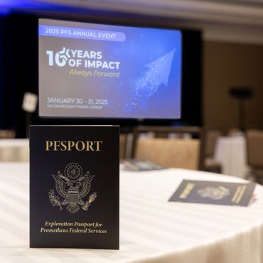 Closeup of custom-made passport on table for company event. Presentation screen in the background.