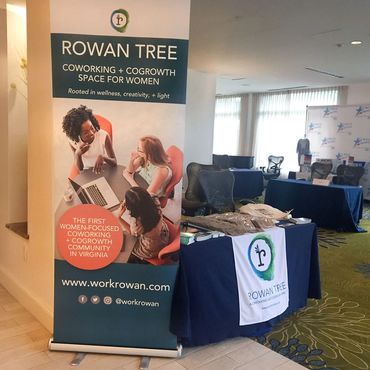 Event bannerstand and table with promotinal items on display.