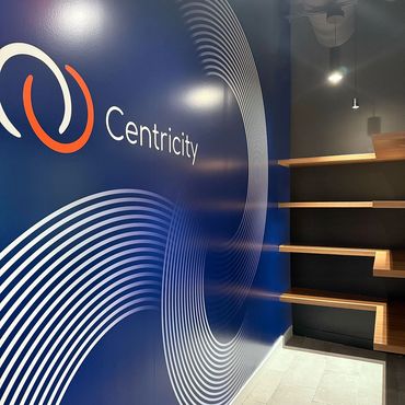 Wall decal with Centricity logo and large circles. Four stacked shelves on the right side.