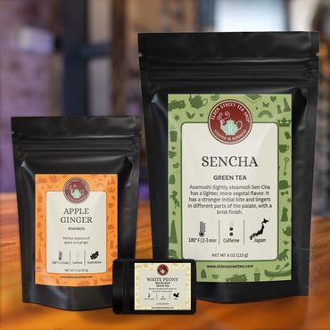 Three pouches of tea on a wooden tabletop.