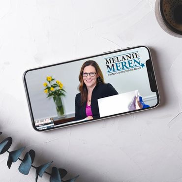 Phone with image of woman in fornt of a computer.