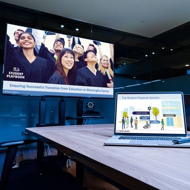 Laptop on table and tv screen showcasing presentation slides.