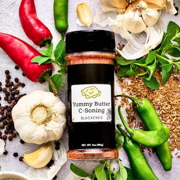 Yummy Butter Blackened C-Soning jar with label and ingredients surrounding jar.