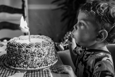 toddler blowing out birthday cake candles