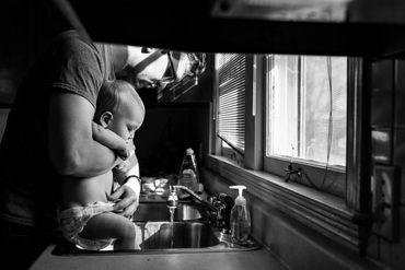 baby getting a bath in the sink from Dad