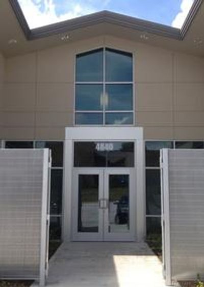 Modern building entrance with glass doors and large windows.