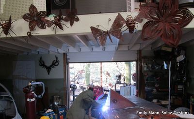Emily Mann welding steel custom mailbox in her home workshop in Tucson, Arizona