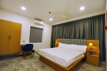 Modern bedroom with wooden furniture and gray curtains.