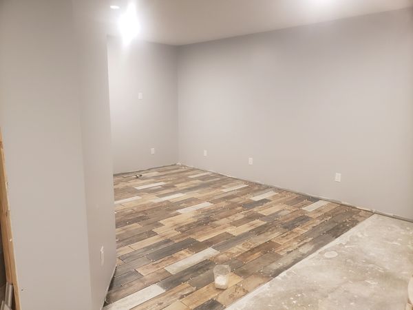 Basement Remodel Progress Picture, Tile Floor being Installed.