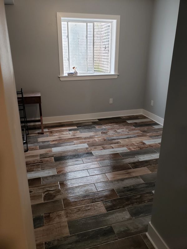 Basement Remodel Progress Picture, Ceramic Tile Installed, Baseboards, and Waiting on Barn Doors