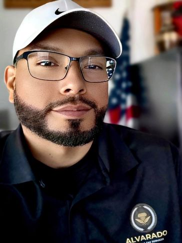 Man wearing glasses and a white Nike cap with an Alvarado uniform.