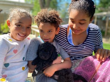 Kids holding puppy.