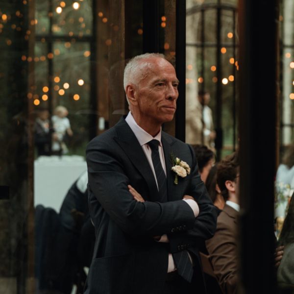 Older man in suit with white boutonniere.