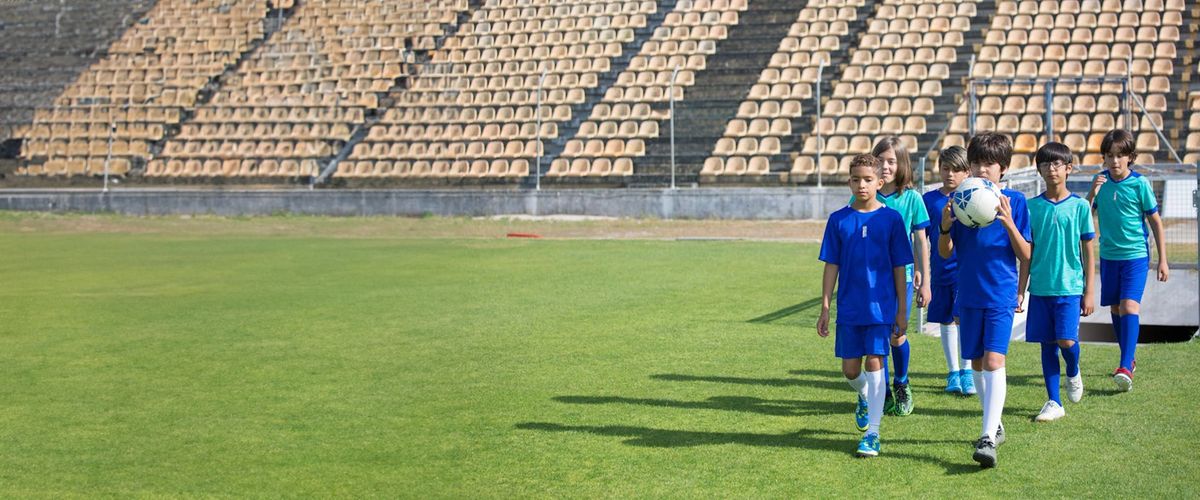 Group of youth soccer players in action, walking on the field in a show of sport and teamwork.